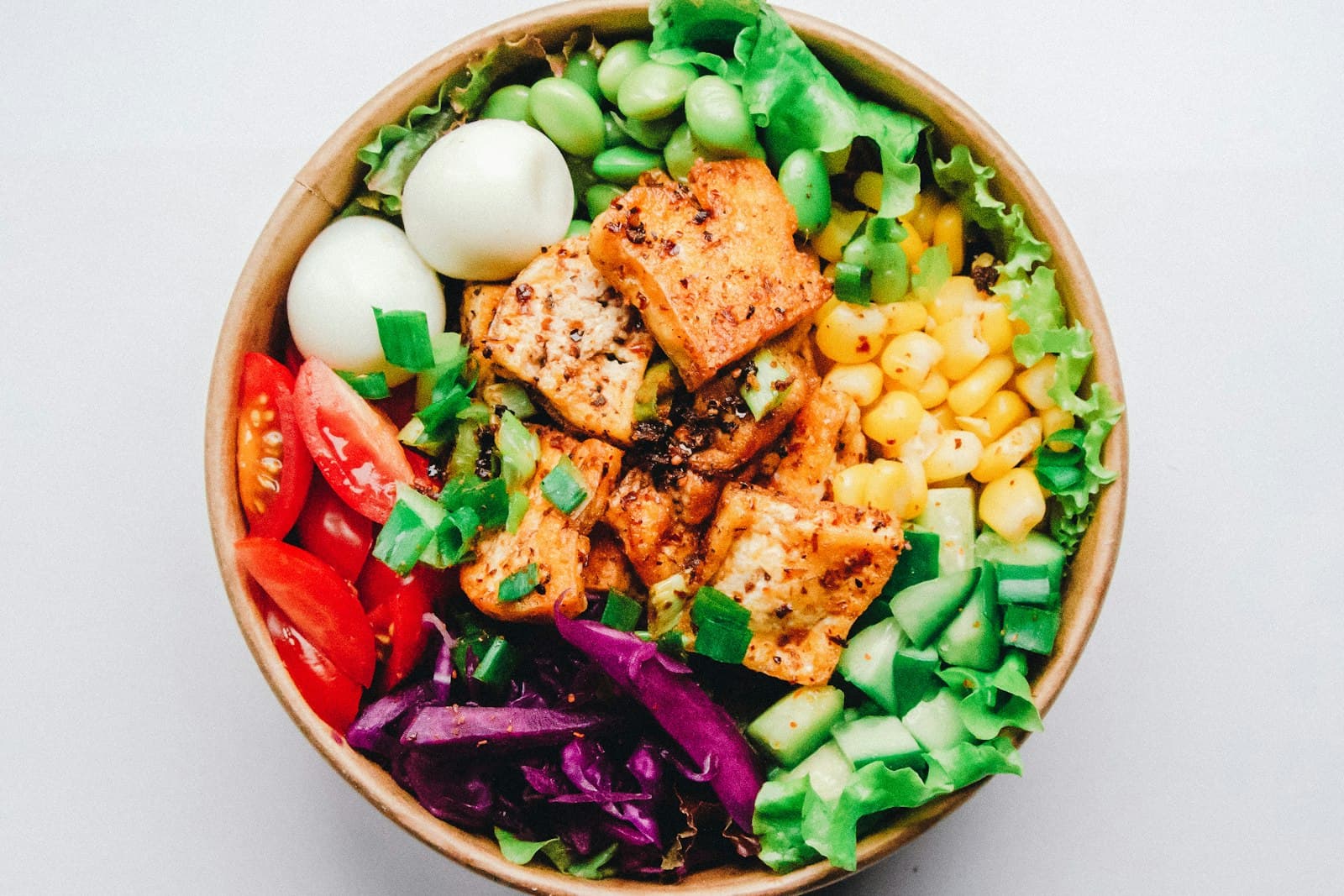 Chicken grain bowl with tomatoes, cabbage and fresh greens